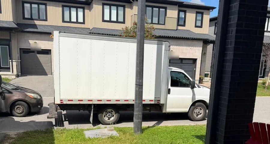 Camion de SK Relocator stationné devant une maison pendant un déménagement